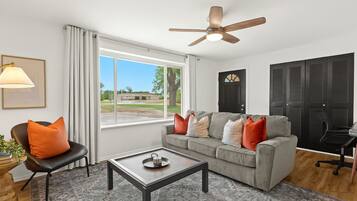 Bright and welcoming living room with oversized window, perfect for relaxing or catching up on your favorite shows.