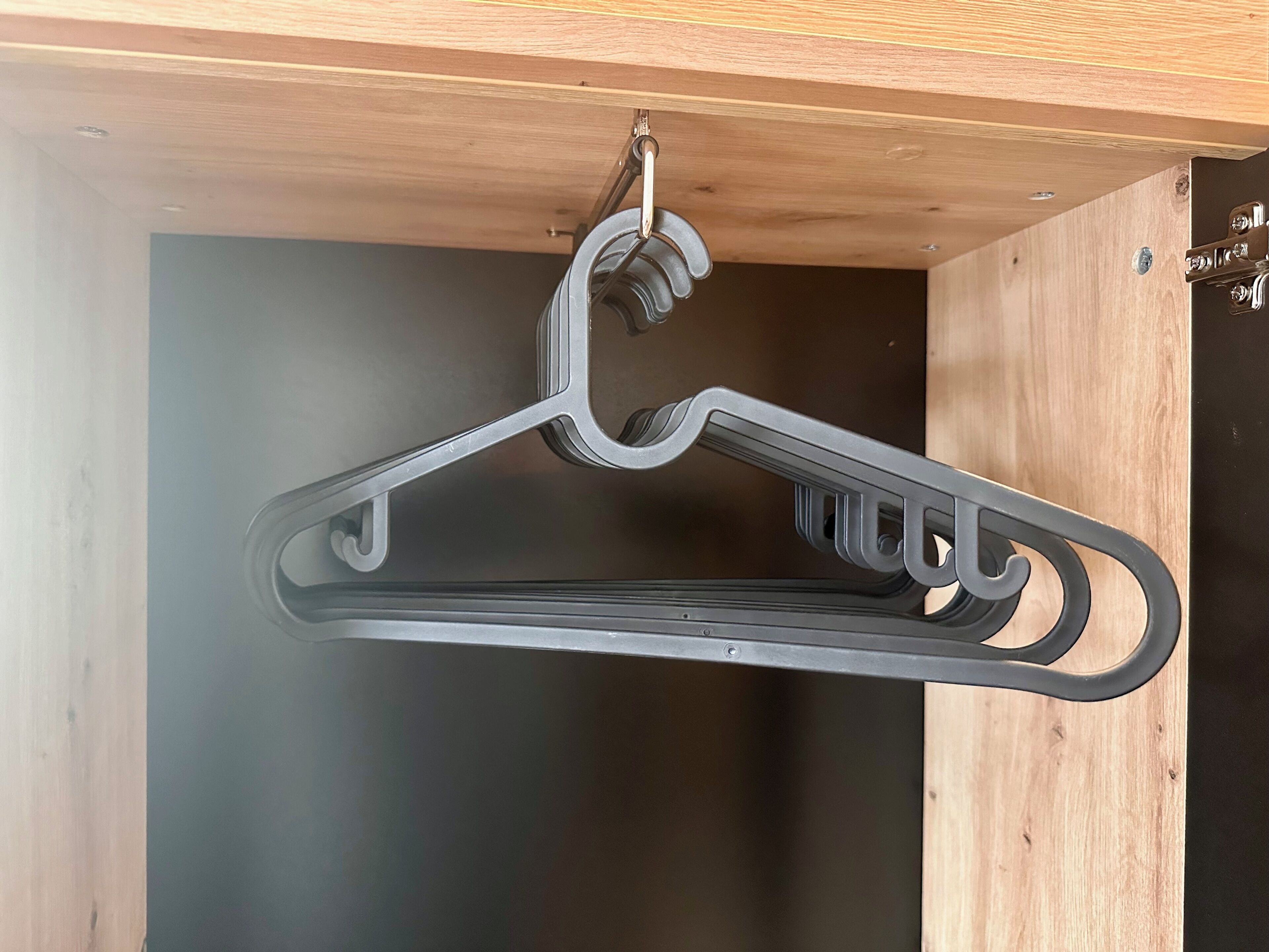 Un perchero de metal negro colgando del techo en una habitación de madera.