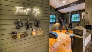A gym with wooden walls, a neon sign reading "Trust Me", and exercise equipment. - Welcome to Tangled Up Cabin! A Luxury Adults Only HotTub/Sauna Playroom (Blue Ridge)