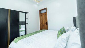 A bedroom with a large bed, a wardrobe, and a door.