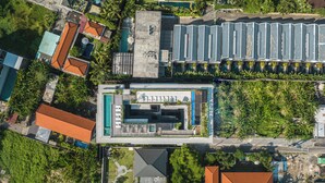 An aerial view of a modern hotel with a swimming pool, multiple guest rooms, and lush greenery surrounding the property. - Body Factory Lifestyle Residence Canggu (Canggu)