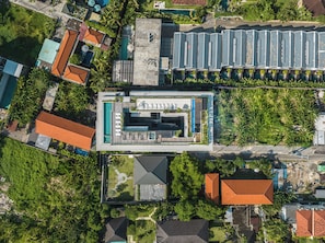 An aerial view of a modern hotel with a swimming pool, multiple guest rooms, and lush greenery surrounding the property. - Body Factory Lifestyle Residence Canggu (Canggu)