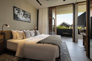 A modern bedroom with a large bed, a flat-screen TV, and a balcony with outdoor furniture. - Body Factory Lifestyle Residence Canggu (Canggu)