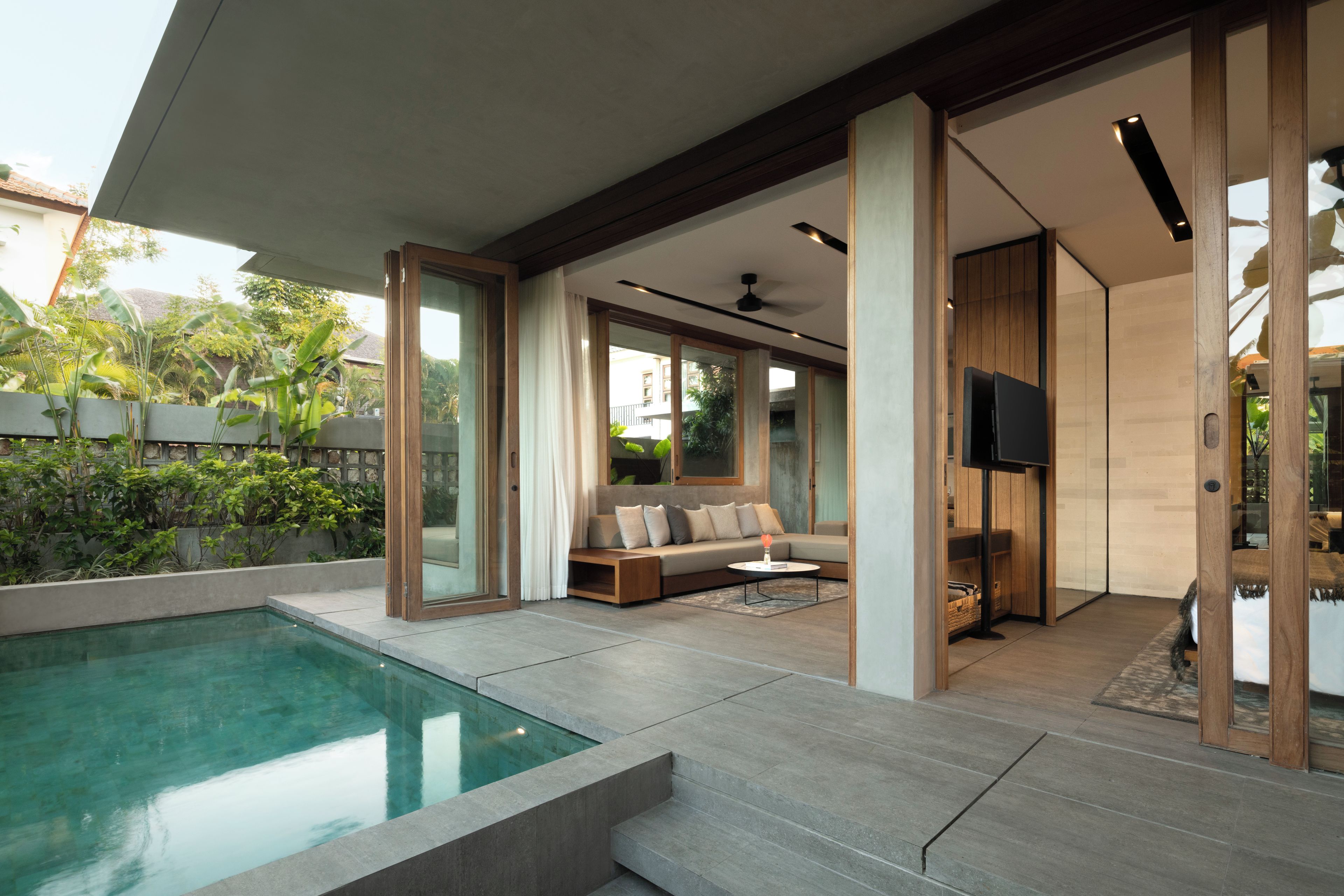 A modern living space with a pool, a sofa set, and a television.