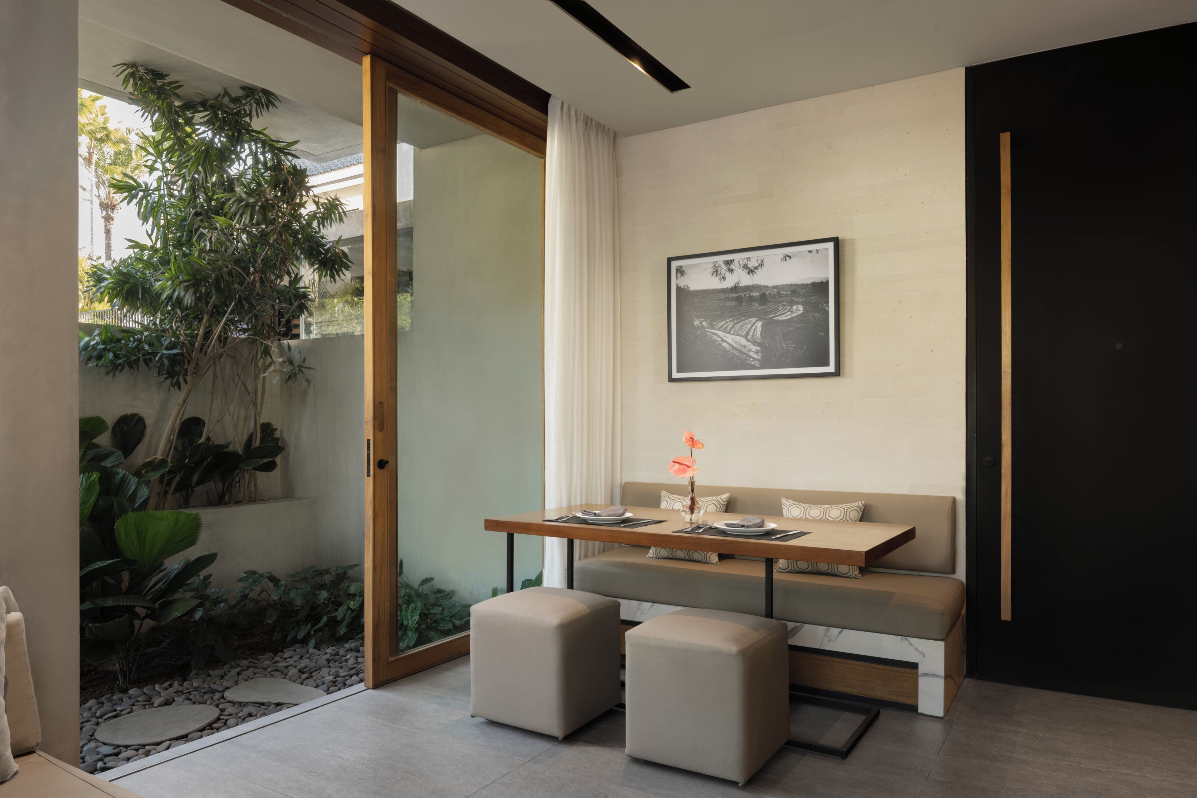Un interior moderno con comedor, sofá y vistas al exterior.