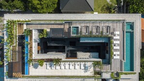 An aerial view of a modern hotel with a rooftop pool, outdoor seating, and lush landscaping. - Body Factory Lifestyle Residence Canggu (Canggu)