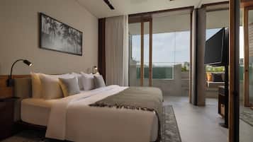 A modern hotel bedroom with a large bed, a flat-screen TV, and a balcony with a view.