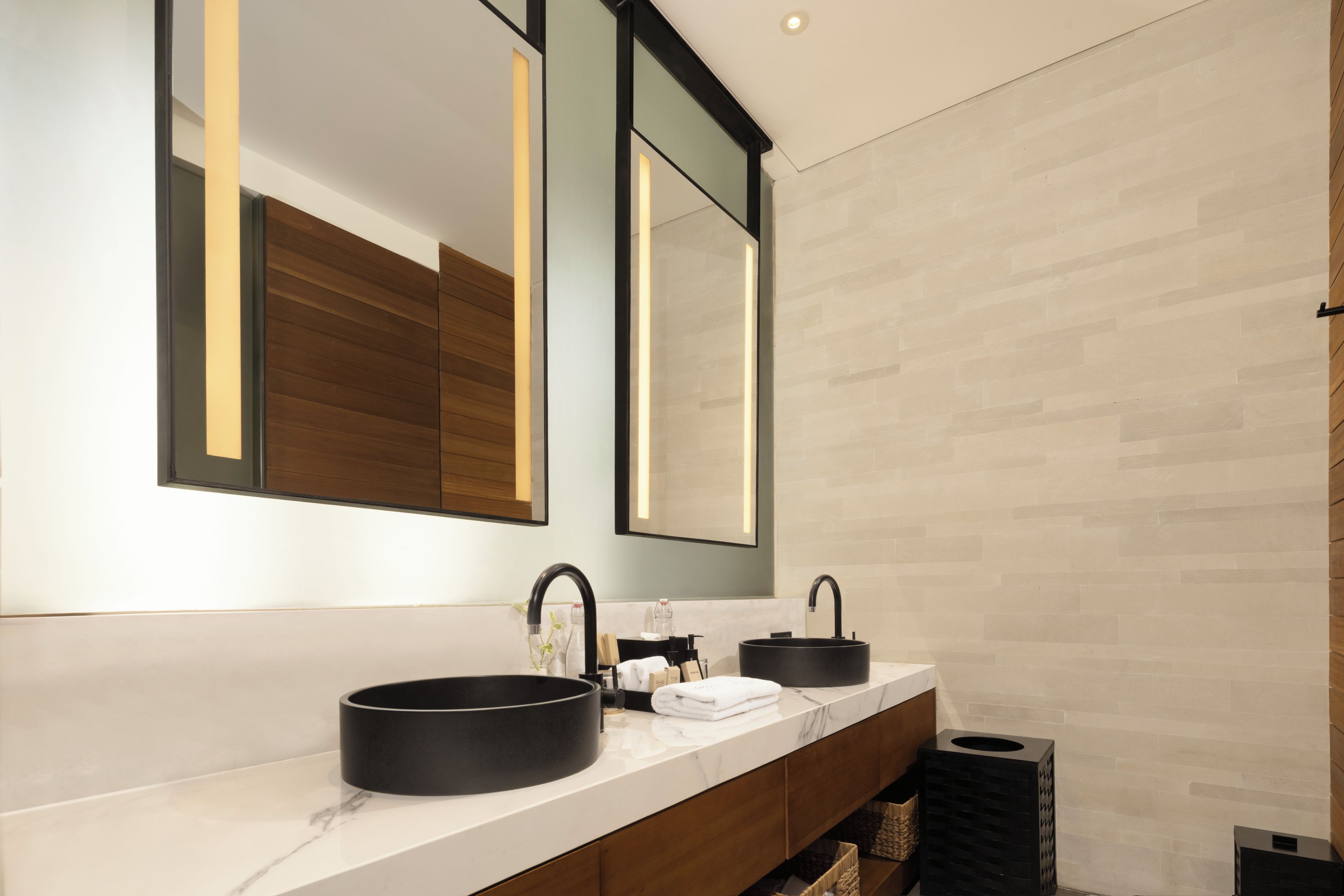 A modern bathroom with a double sink, a large mirror, and a marble countertop.