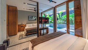 Ein modernes Schlafzimmer mit einem großen Bett, einem Fernseher und Blick auf Pool und Garten.