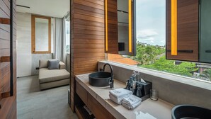 Ein modernes Badezimmer mit einem großen Fenster, einem Waschbecken und einem Spiegel.