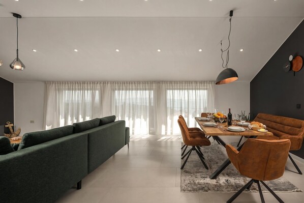 Un comedor moderno con una mesa de madera dispuesta para cuatro personas, rodeada de sillas tapizadas.