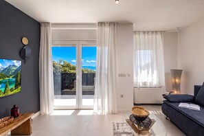 Una sala de estar moderna con un sofá, un televisor de pantalla plana y una mesa de comedor.