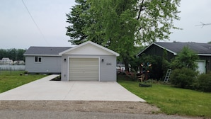 A single-story house with a garage, a driveway, and a mailbox. - Newly Renovated, Lakefront, Dog Friendly Cottage, Sand Lake, Harrison (Harrison)