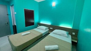 A room with two beds, a wall-mounted light, and a door. - Qish Hotel (Malacca City)