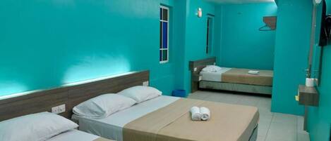 A hotel room with two beds, a window, an air conditioning unit, and a mirror.