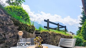 A table set outdoors with a view of mountains and a wooden fence in the background. - Galliweidli by Interhome (Wengen)