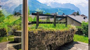 A view of a mountainous landscape with a wooden fence and a stone wall in the foreground. - Galliweidli by Interhome (Wengen)