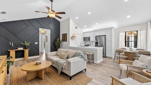 Una sala de estar moderna con un sofá, una mesa de centro y un ventilador de techo.