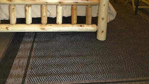 A tent with a bed, pillows, and a table with chairs inside.