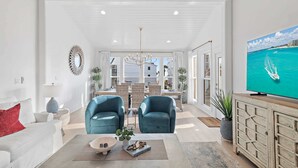 A modern living room with a sofa, two armchairs, a coffee table, a TV, and a view of the sea. - Steps to the Private Beach, BRAND NEW renovations, 3 Bikes - 30A Sun Joy (Santa rosa beach)