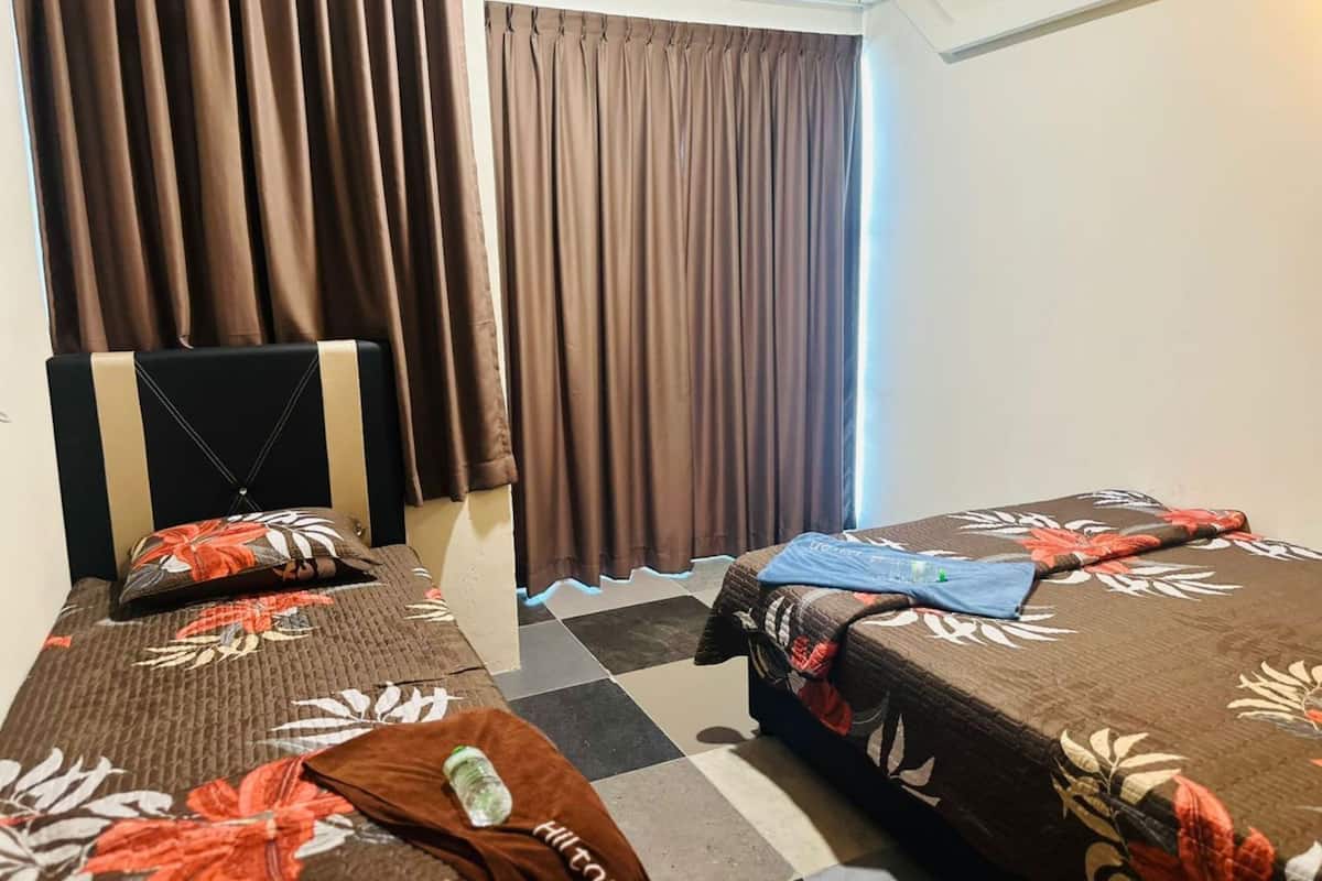 A hotel room with two beds, a window with curtains, and a checkered floor.
