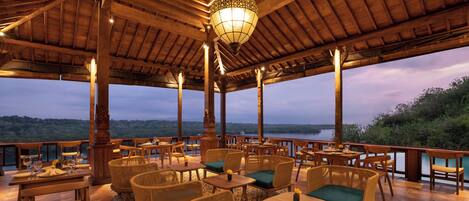 An outdoor seating area with wicker furniture and a view of the landscape.