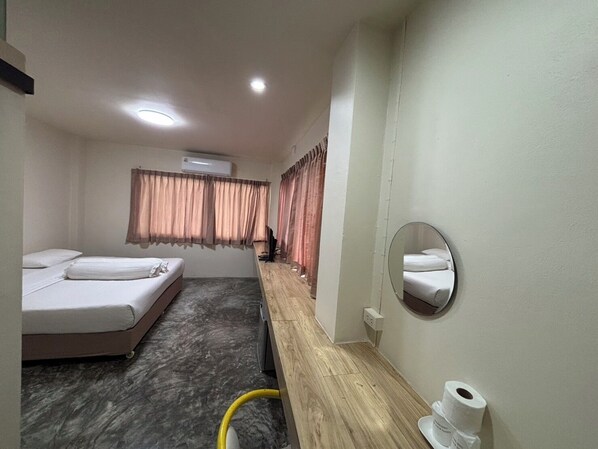 A hotel room with two beds, a wooden bench, a mirror, a toilet, and an air conditioning unit. - LITHAI BOUTIQUE HOTEL (Phitsanulok)