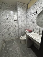Un baño con inodoro, bidé y lavamanos.