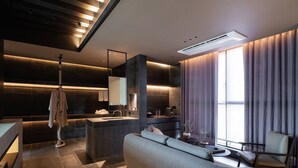 A modern living room with a sofa, a coffee table, and a dining area with a bar. - Busan Gwangalli The Moor Hotel (Busan)