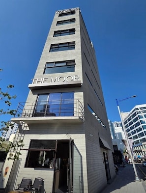 A modern building with "THE MOOR" signage, featuring a balcony, large windows, and a visible entrance. - Busan Gwangalli The Moor Hotel (Busan)