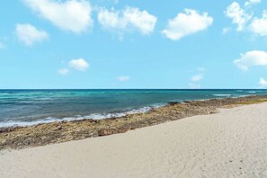Una playa con agua azul cristalina y una orilla arenosa.