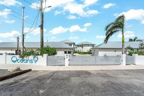 A gated property with a sign reading "Oceans 9". - Oceans 9 LUXE | 4BR Beachfront Villa in West Bay (West Bay)