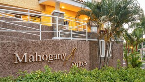 Segnaletica per Mahogany Suites, con parete in pietra e una scala che conduce a un'area coperta.