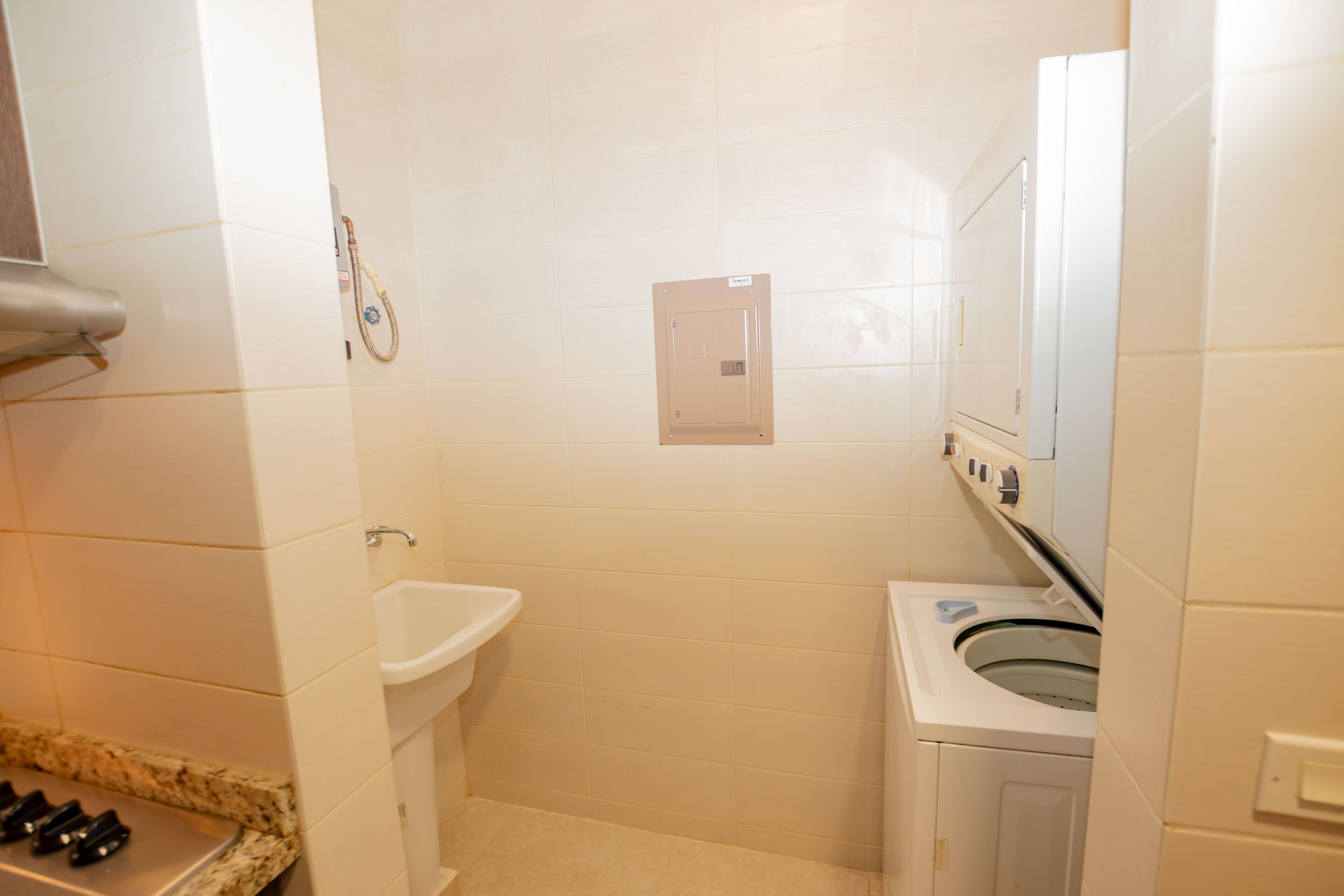Un baño con lavamanos, inodoro y lavadora.
