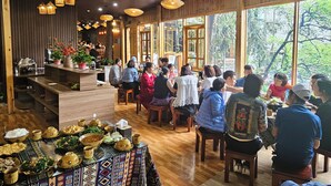 Ein Restaurant mit Holzvertäfelungen, großen Fenstern und verschiedenen Gerichten auf den Tischen.