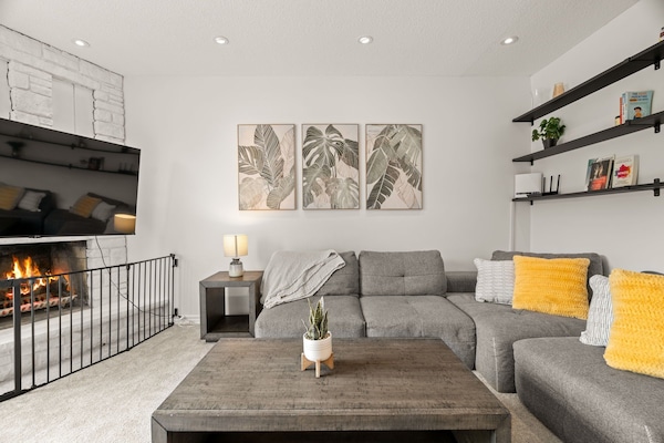 Cozy living room with roomy couch, smart TV, and dimmable lights.