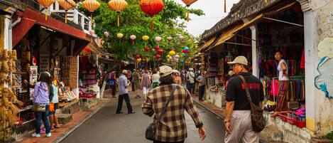A narrow street lined with shops and hanging lanterns.