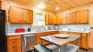 A kitchen with wooden cabinets, a stainless steel refrigerator, a sink, and a countertop with a red toaster. - 18 Mi to Red River Gorge: Beattyville Retreat (Beattyville)