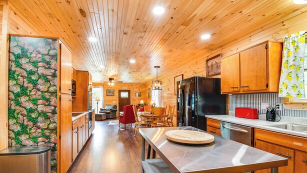 A wooden interior with a kitchen area, dining table, and chairs. - 18 Mi to Red River Gorge: Beattyville Retreat (Beattyville)