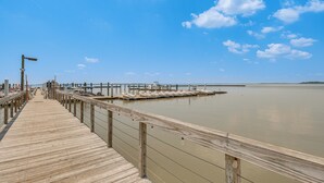 A wooden pier extending into calm water with a clear sky. - Resort Condo w/ Marina Access in Williamsburg! (Williamsburg)