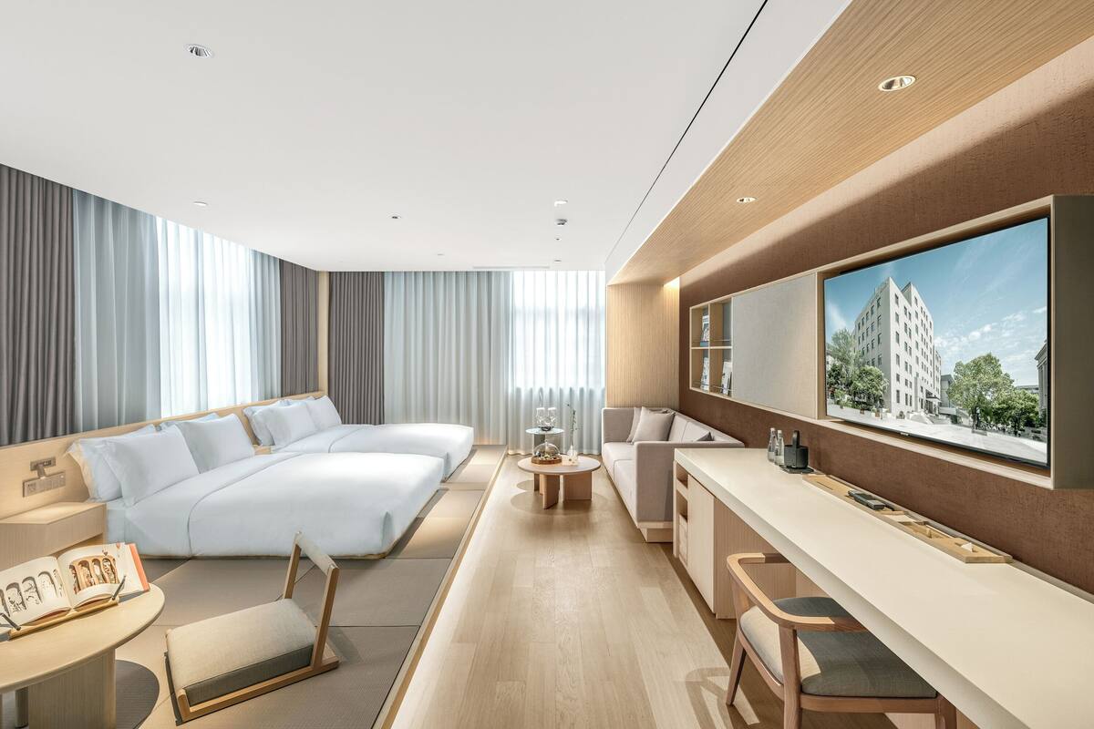 Une chambre d’hôtel moderne équipée d’un grand lit, d’un bureau, d’un canapé et d’une télévision.