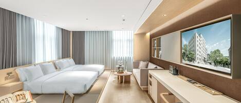 A modern hotel room with a large bed, a desk, a sofa, and a TV.