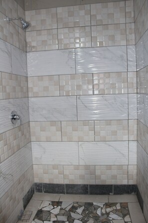 Een douche, handdoeken, zeep, toiletpapier