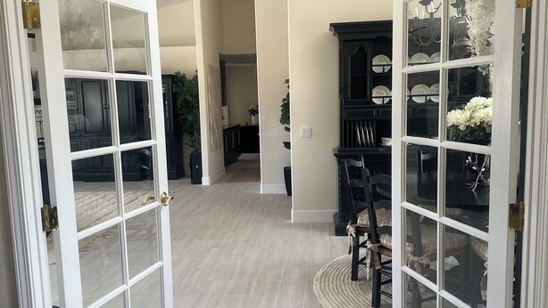 A spacious open-plan living area with a dining area, a black cabinet with glass doors, and a light-colored floor. - Charming 4-br Wine Country Retreat — Walk Downtown Solvang + BBQ & Fireplace (Solvang)