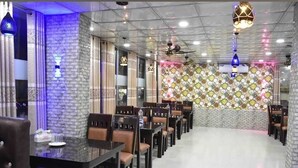 A restaurant with a long dining area, multiple tables, and chairs. - Hotel Grand Valley (Bandarban)