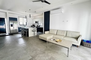 A modern kitchen with a central island, bar stools, and a built-in oven.