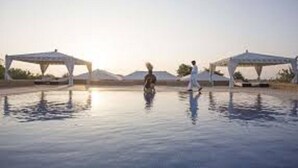 A pool area with two white gazebos and a person walking. - Prime Desert Camp - Jaisalmer (Jaisalmer)