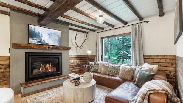 A cozy living room with a fireplace, a sofa, and a coffee table.