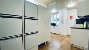 A modern kitchen with white cabinetry, a microwave, and a sink. - ZIMMERzuVERMIETEN.ch Biberist (Biberist)