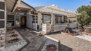 A house with a covered porch, a stone facade, and a gravel driveway. - Spacious 5-bedroom house in delightful Glendale with WiFi, AC (Glendale)